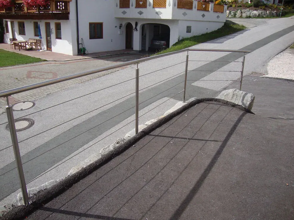 Edelstahl-Handlauf an einer gepflasterten Rampe