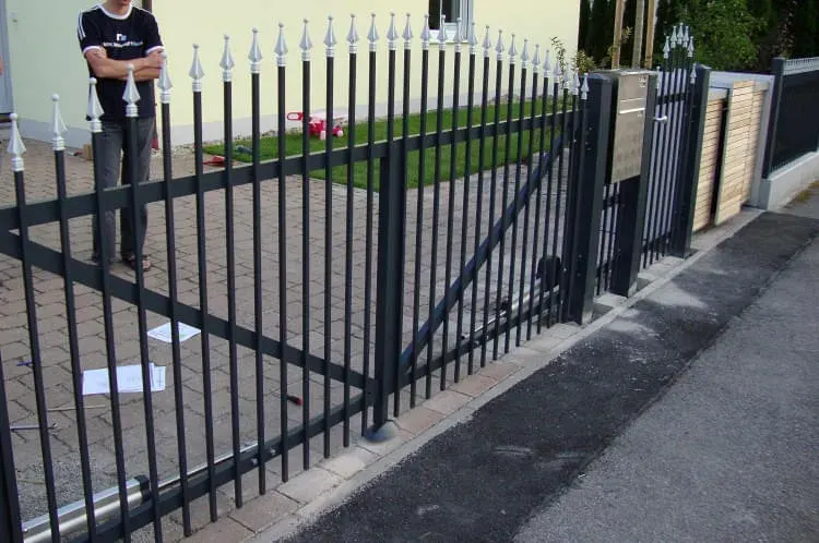 Geschmiedeter Zaun mit Spitzenstäben vor einem Wohnhaus