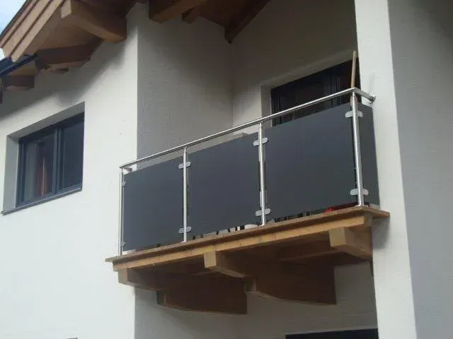 Balkon mit anthrazitfarbenen Glasfeldern an einem Neubau