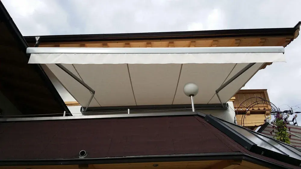 Ausgefahrene Markise über einem Balkon, von unten fotografiert