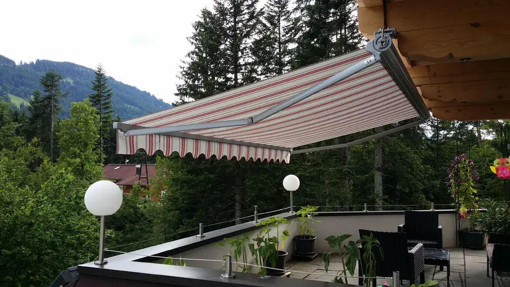 Gelenkarm-Markise über einer Terrasse in Tirol